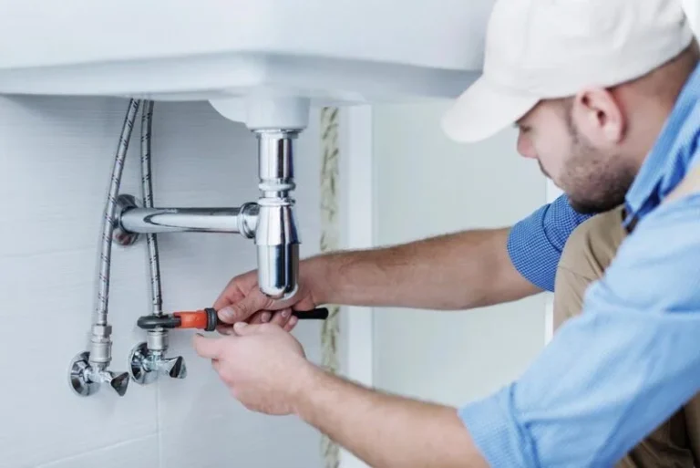plumber repairing sink plumbing in home