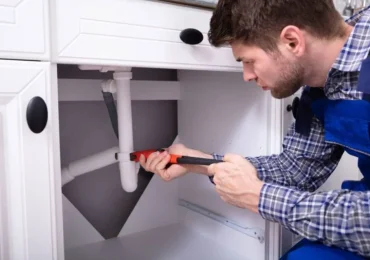 plumber-repairing-the-bathroom-sink-plumbing-in-a-residential-property-in-newark plumber repairing the bathroom sink plumbing in a residential property in newark