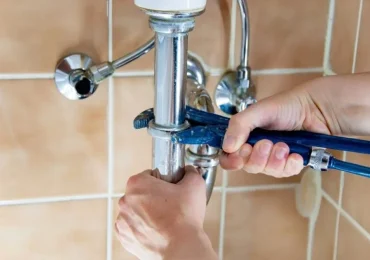 plumber repairing a water pipe in a bathroom